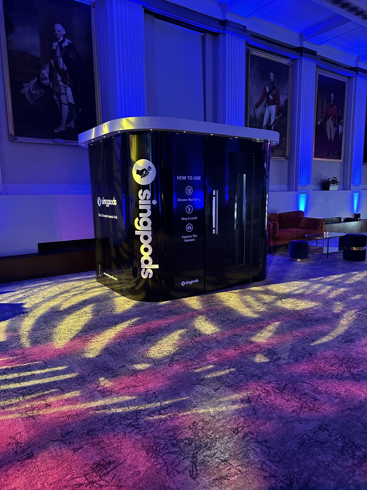 SingPods pod lit up at an evening event